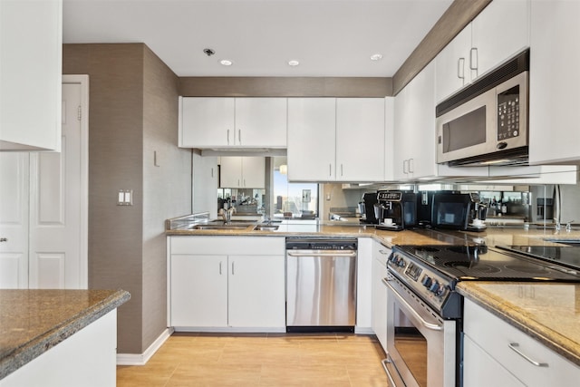 kitchen with white cabinets, stone counters, sink, and appliances with stainless steel finishes