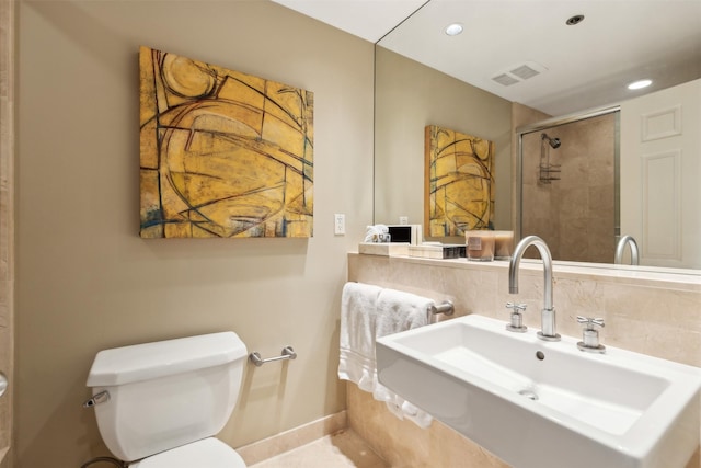 bathroom featuring sink, an enclosed shower, and toilet