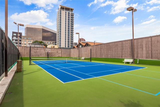 view of tennis court with basketball hoop