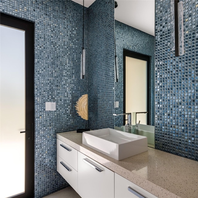 bathroom with vanity and tile walls