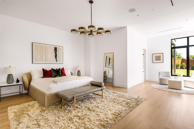 bedroom featuring an inviting chandelier and hardwood / wood-style flooring