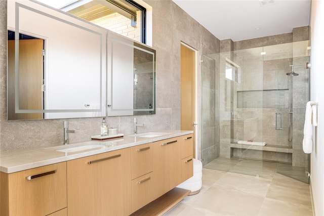 bathroom featuring vanity, tile patterned flooring, tile walls, tasteful backsplash, and a shower with shower door