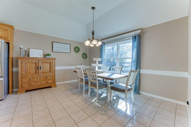 tiled dining room featuring a chandelier and vaulted ceiling