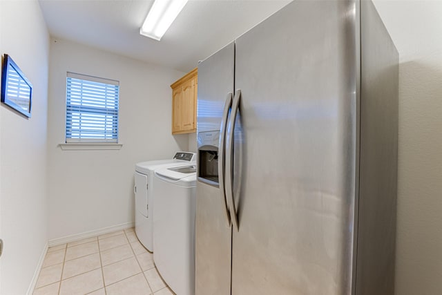 washroom featuring washer and clothes dryer, light tile patterned flooring, and cabinets