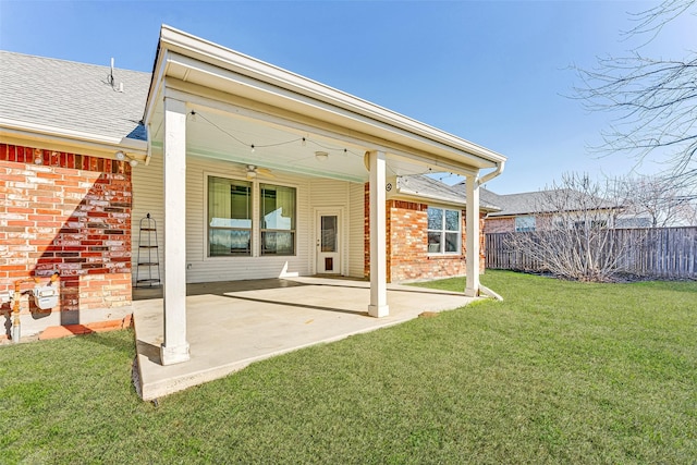 rear view of property featuring a lawn, ceiling fan, and a patio