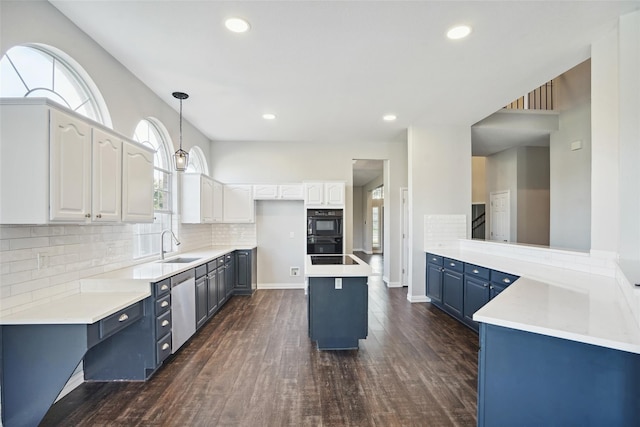 kitchen with a kitchen island, sink, white cabinetry, and blue cabinets