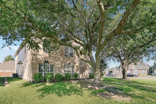 view of front of house with central air condition unit and a front lawn