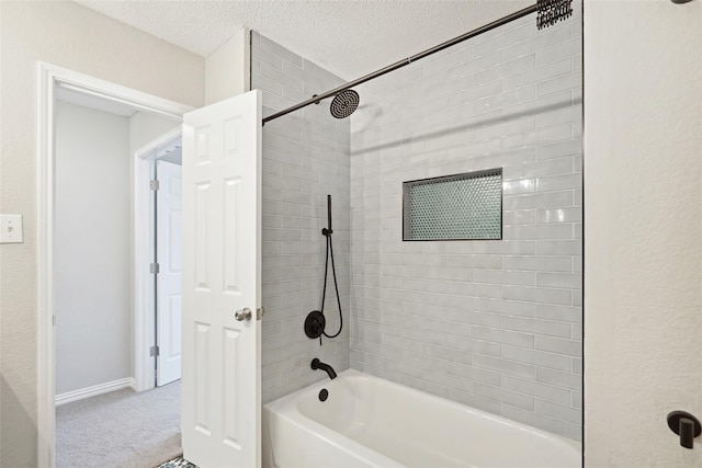 bathroom featuring tiled shower / bath combo and a textured ceiling