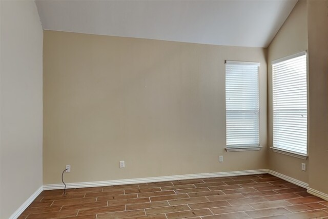 empty room featuring plenty of natural light and lofted ceiling