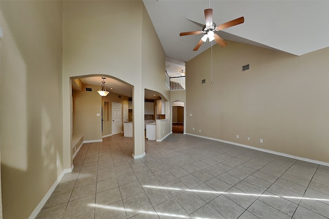 unfurnished living room with ceiling fan, light tile patterned flooring, and high vaulted ceiling