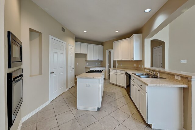 kitchen with white cabinetry, built in microwave, sink, a center island, and kitchen peninsula