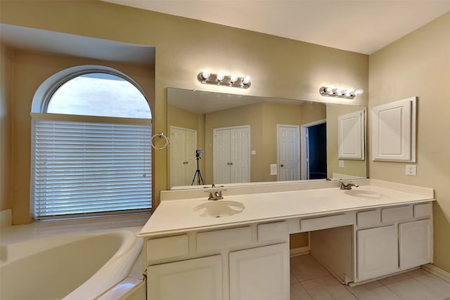 bathroom with tile patterned flooring, vanity, and a tub