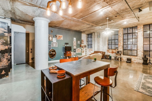 kitchen with ceiling fan, decorative columns, and concrete floors