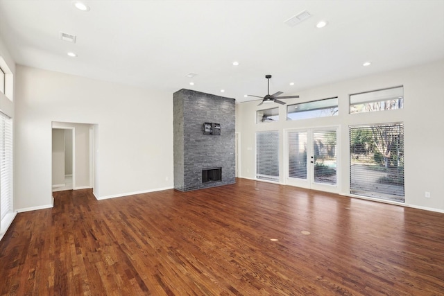 unfurnished living room featuring ceiling fan, dark hardwood / wood-style floors, and a fireplace