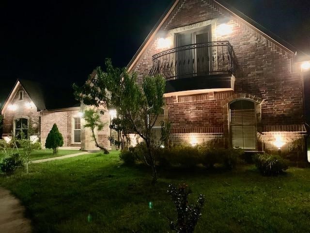 exterior space featuring a balcony and a lawn