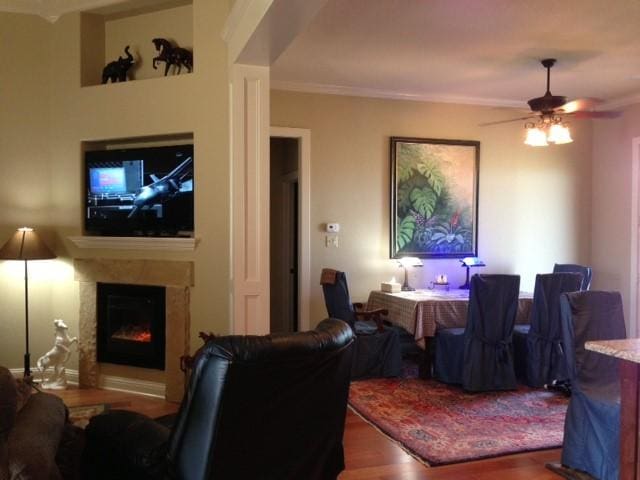 living room with wood-type flooring, ceiling fan, and ornamental molding