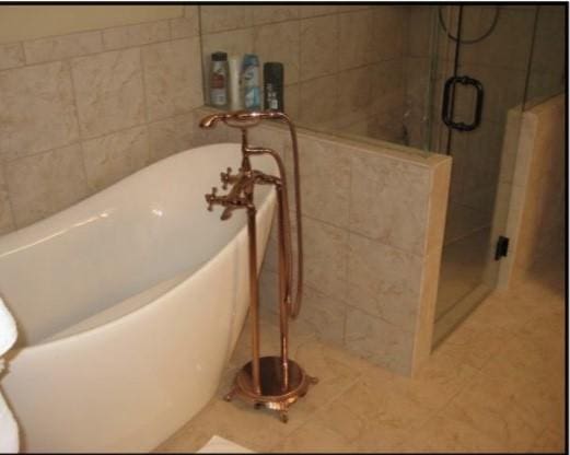 bathroom with tile patterned flooring and separate shower and tub