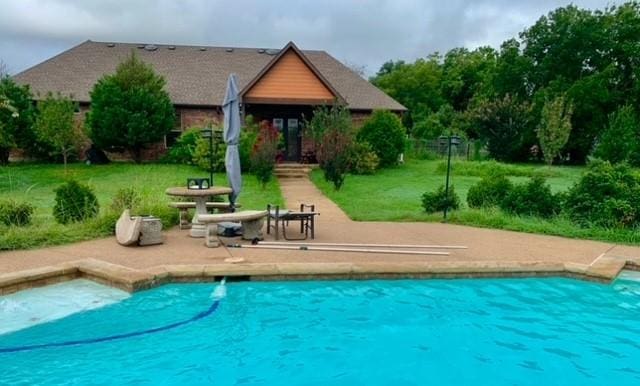 view of swimming pool featuring a patio area and a lawn