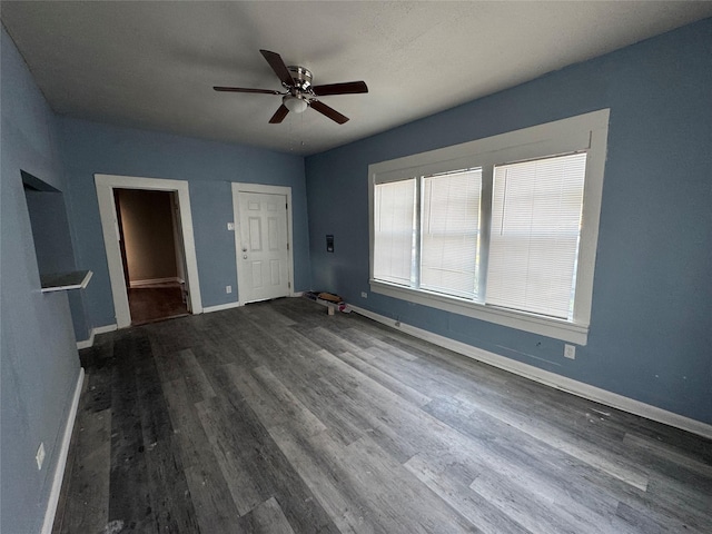 unfurnished bedroom with ceiling fan and dark hardwood / wood-style flooring