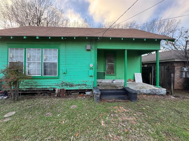 back of house featuring a patio area and a lawn