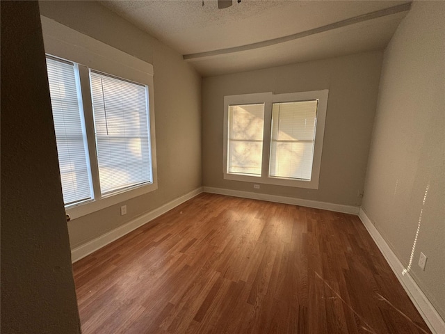 spare room with wood-type flooring and a textured ceiling