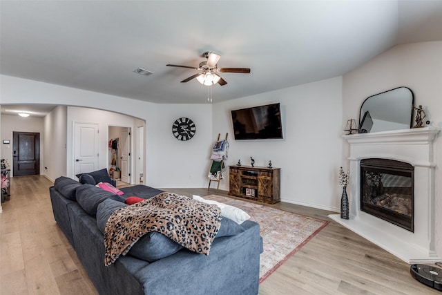 living room featuring light hardwood / wood-style flooring, ceiling fan, and lofted ceiling