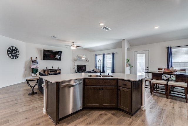 kitchen with dishwasher, light wood-type flooring, a center island with sink, and sink