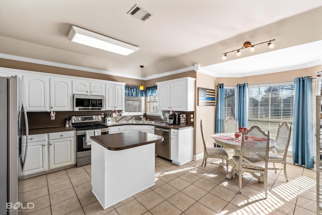 kitchen with white cabinetry, pendant lighting, light tile patterned floors, and stainless steel appliances