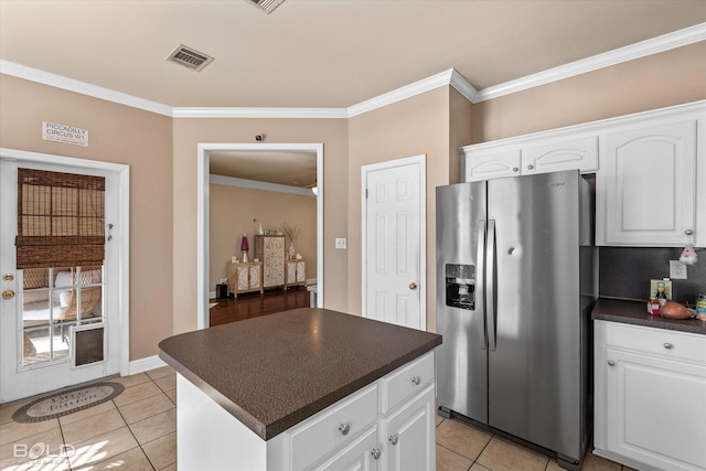 kitchen with white cabinetry, stainless steel fridge with ice dispenser, crown molding, and light tile patterned flooring