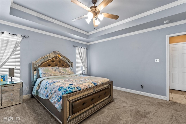 carpeted bedroom with ceiling fan, a raised ceiling, and ornamental molding