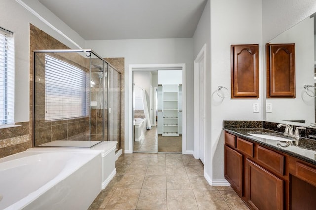 full bathroom featuring a spacious closet, vanity, a shower stall, tile patterned flooring, and a bath