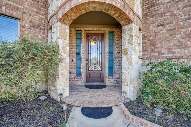 doorway to property featuring brick siding