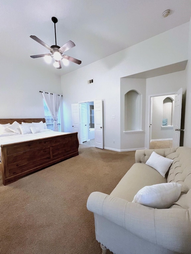 bedroom featuring connected bathroom, light colored carpet, and ceiling fan