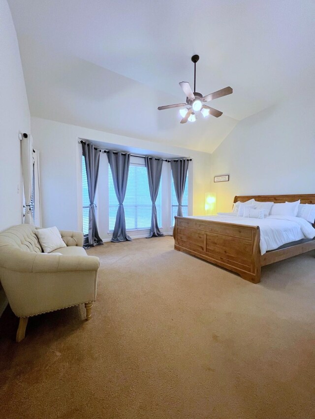 unfurnished bedroom with ceiling fan, vaulted ceiling, and light carpet