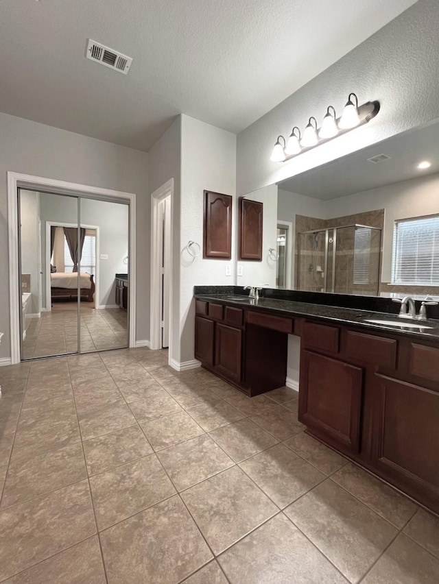 full bathroom with a textured ceiling, tile patterned flooring, visible vents, baseboards, and a stall shower