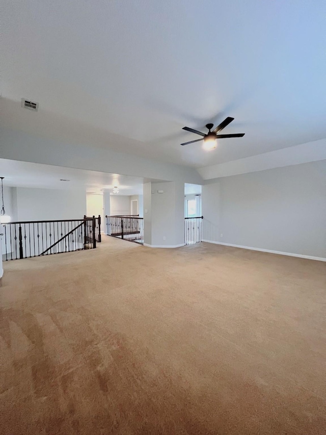 spare room featuring carpet floors, baseboards, visible vents, and a ceiling fan