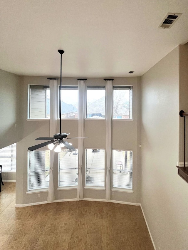 interior details featuring baseboards, visible vents, and a ceiling fan