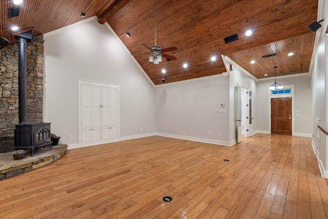 unfurnished living room featuring ceiling fan, crown molding, light hardwood / wood-style flooring, high vaulted ceiling, and a wood stove