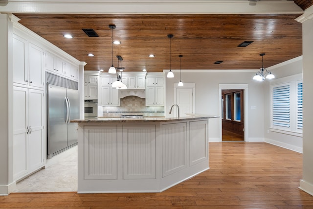 kitchen with hanging light fixtures, stainless steel appliances, tasteful backsplash, a center island with sink, and wood ceiling