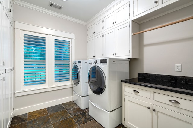 clothes washing area featuring a wealth of natural light, washer and dryer, cabinets, and ornamental molding