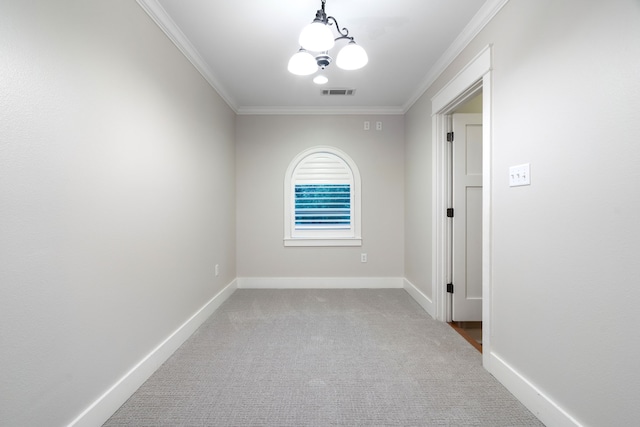 spare room featuring carpet flooring, a chandelier, and ornamental molding