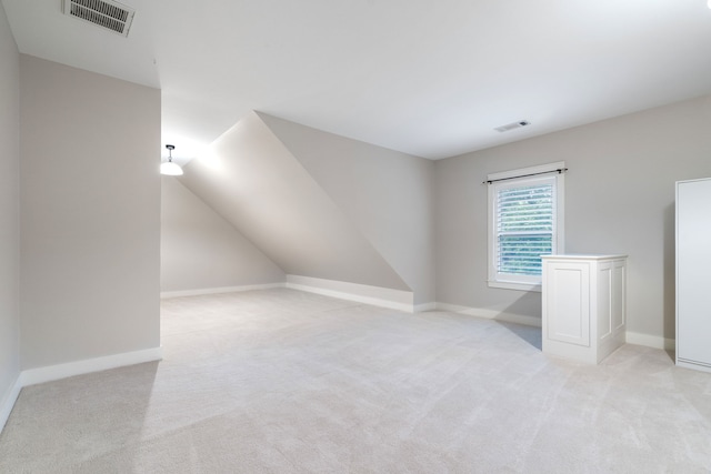 additional living space with light carpet and vaulted ceiling