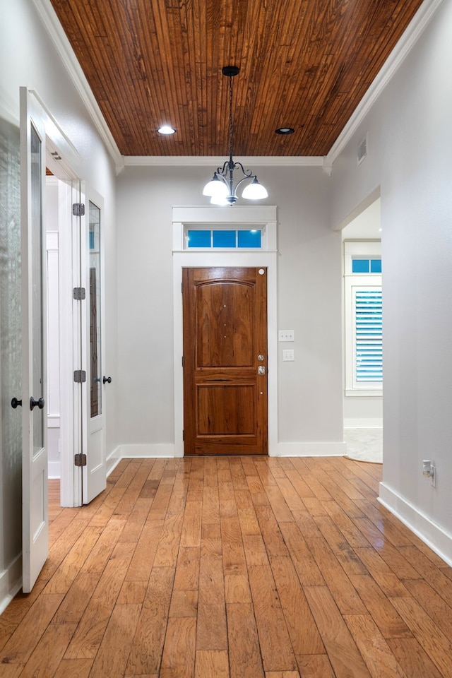 entrance foyer featuring ornamental molding, wood ceiling, and light hardwood / wood-style flooring