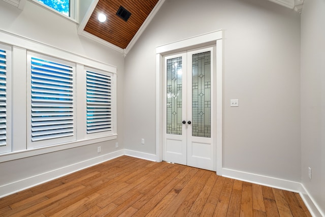 entryway featuring french doors, wooden ceiling, hardwood / wood-style floors, vaulted ceiling, and ornamental molding