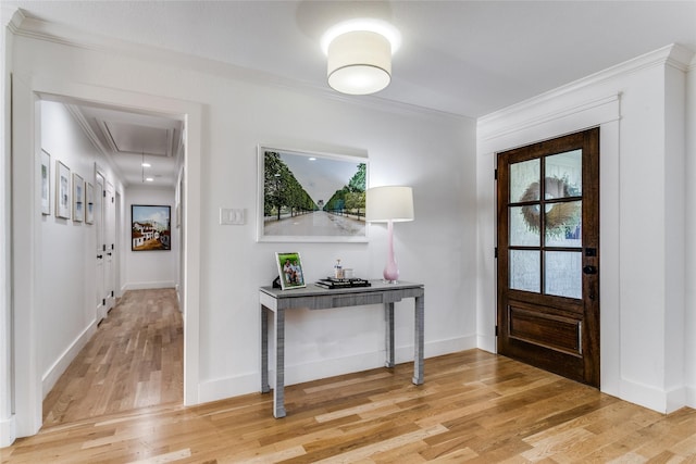 foyer entrance featuring crown molding and hardwood / wood-style flooring