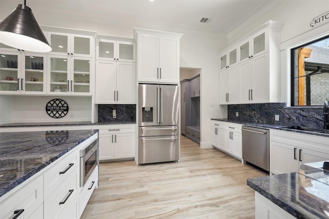 kitchen with white cabinets, decorative light fixtures, sink, and stainless steel appliances