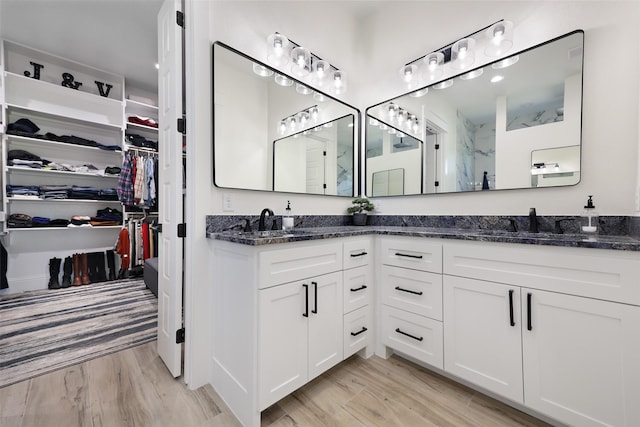 bathroom featuring hardwood / wood-style floors, vanity, and a shower