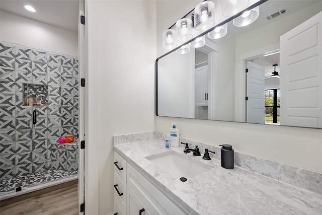 bathroom with wood-type flooring, vanity, and walk in shower