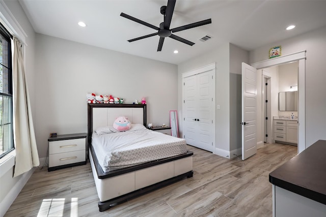 bedroom featuring ceiling fan, a closet, ensuite bathroom, and light hardwood / wood-style floors