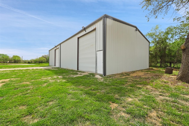 view of outbuilding featuring a lawn and a garage